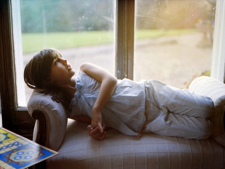 Girl relaxes on a chaise longue, Somerset, UK, 2008
