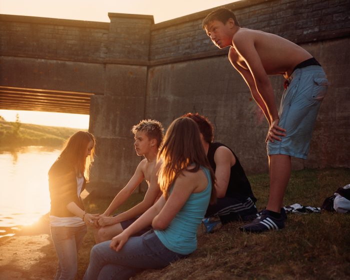 Teenagers hang out by the river. Somerset, UK